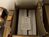 View of unopened box containing the desktop monitor mount with installation instructions on top.