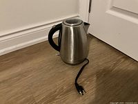 Front and side views of the stainless steel electric kettle with black handle and water level indicator, showing the spout and power cord with plug