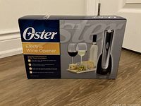 Front view of boxed Oster Electric Wine Opener with product image and features.