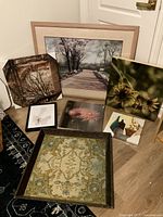 View of all seven paintings arranged together on the floor showing variety in size and style