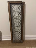 Full frontal view of the vintage wooden window frame with decorative leaded glass showing diamond pattern.