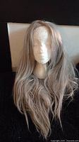 Front view of the long silver wavy real human hair wig on a mannequin head showing hair length and quality.