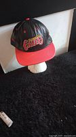 Front view of Kansas City Chiefs leather baseball cap showing logo, black crown, and red brim.