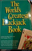 Green hardcover book titled 'The World's Greatest Blackjack Book' with author's names visible, provides blackjack strategy.