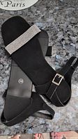 Photo of black flat sandals size 39 with bling strap detail on black surface
