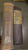 Spine view of two antique books 'Under the African Sun' by Ansorge and 'Inside Africa' by John Gunther.