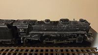 Black metal locomotive engine numbered 2037 on O scale track