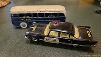 Side angle of police car with BOAC bus in background to show lot items