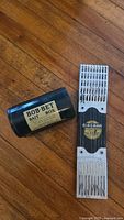 Bob-Bet bait box and Niagara fishing hook holder placed on wooden floor