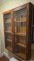 Front view of oak cabinet with double glass doors and interior shelves