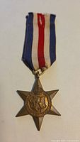 Full view of the WWII Canadian France and Germany Star medal with original ribbon showing the ribbon colors and star shape.