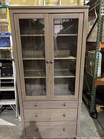 Full front view of cabinet showing glass doors and drawers