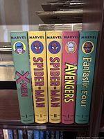 Five TASCHEN hardcover volumes standing upright showing spines for X-Men, two Spider-Man, Avengers and Fantastic Four