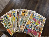 Fan of 13 DC Comics issues laid out on wood table