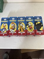 Five collectible Disney Comics and Stories tins lined up front view