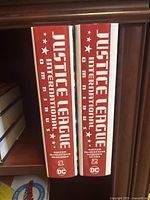 Spines of both volumes showing title and volume numbers on red and white backgrounds