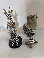 Group shot of all four black and white checkered Mackenzie-Childs animal figurines on white background