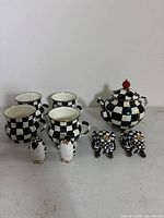 Overview shot of teapot, four mugs, and two frog shakers