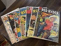 Seven Red Ryder Dell comics lying spread on a floor