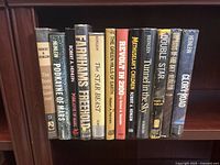 Photo showing spine view of 12 hardcover Robert A. Heinlein books lined up on a shelf including titles The Door into Summer, Podkayne of Mars, Farmer's Freehold, The Star Beast, and others.
