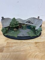 Front view of the Green Dragon Inn collectable, showing roof, doors, windows, foliage and base details.