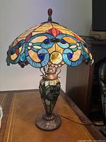 Front view of lamp fully assembled on wooden surface, showing shade and base