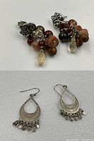 Two pairs of sterling silver earrings: one pair Bradford Exchange engraved silver earrings with dangling discs, one pair silver stud earrings with dangling gemstone and bead clusters.