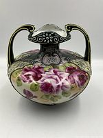 Front view of antique Nippon footed porcelain vase with handles and floral decorations