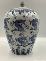 Front angle of the blue and white porcelain ginger jar with koi fish pattern.