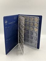 Open blue Uni-Safe coin album showing multiple Canadian dimes in transparent sleeves.
