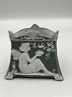 Front view showing fairy holding crown and bird with floral branch on green jasperware background.