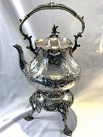 Frontal view of kettle on stand, showing overall shape and decorative details