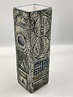 Oblique view showing overall shape and relief motifs on two adjacent sides.