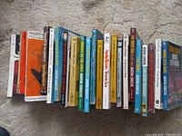 Full view of 21 vintage Agatha Christie books arranged standing, showing various titles and colorful covers mostly in paperback form.