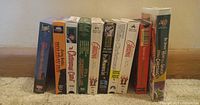 Side view showing all 10 VHS tapes upright in a row with titles visible on the spines.