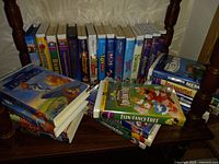 Wide image showing around two dozen Disney VHS tapes both stacked and lined up, featuring classic animated titles.