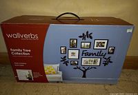 Closed box showing Wallverbs Family Tree Collection with family tree wall frame design including 10 photos and decorative frame parts in black finish.