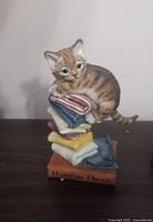 Figurine of tabby cat on stacked towels with 'Hang in There' base