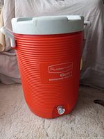 Front view of large orange Rubbermaid water jug showing brand and spigot