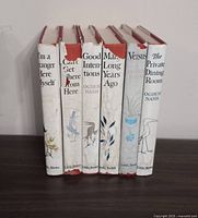 Six Ogden Nash hardbound books standing upright, showing spines with titles and author. Dust jackets mostly white with red tops and illustrative drawings. Titles are visible on spine.