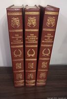 Three volumes of William Shakespeare's works in brown hardcover with gold embossing, spine titles shown