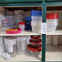 Shelves with multiple plastic and glass food storage containers with lids of various sizes and colors