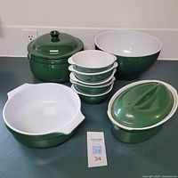Full view of all items showing two covered casseroles, one large bowl, and four smaller bowls stacked.