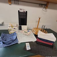 Photo showing dish rack, new dish drying mat, assorted dish towels, napkins, napkin holder, paper towel holder, black plastic dish tray, and Lazy Susan on tabletop.