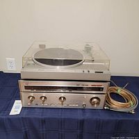Front view of stacked Hitachi turntable, Luxman amplifier and tuner with cables