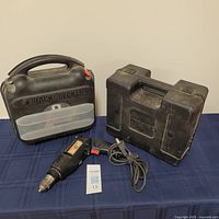 Black & Decker drill with hard plastic black carrying case, Wagner sprayer case next to drill and power cord visible