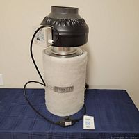 Full view of the black and silver Vivo Home inline duct fan with power cord and filter sleeve.