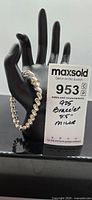 Photo of the bracelet hanging on a black hand display with auction lot notes showing brand Milor, 8.5 inch length, and 925 sterling silver.