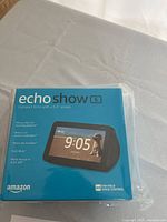 Front view of Amazon Echo Show 5 box with product image and details showing 5.5-inch screen, voice control, and Alexa compatibility.