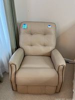 Front view of cream leather electric recliner showing tufted back and nail head trim